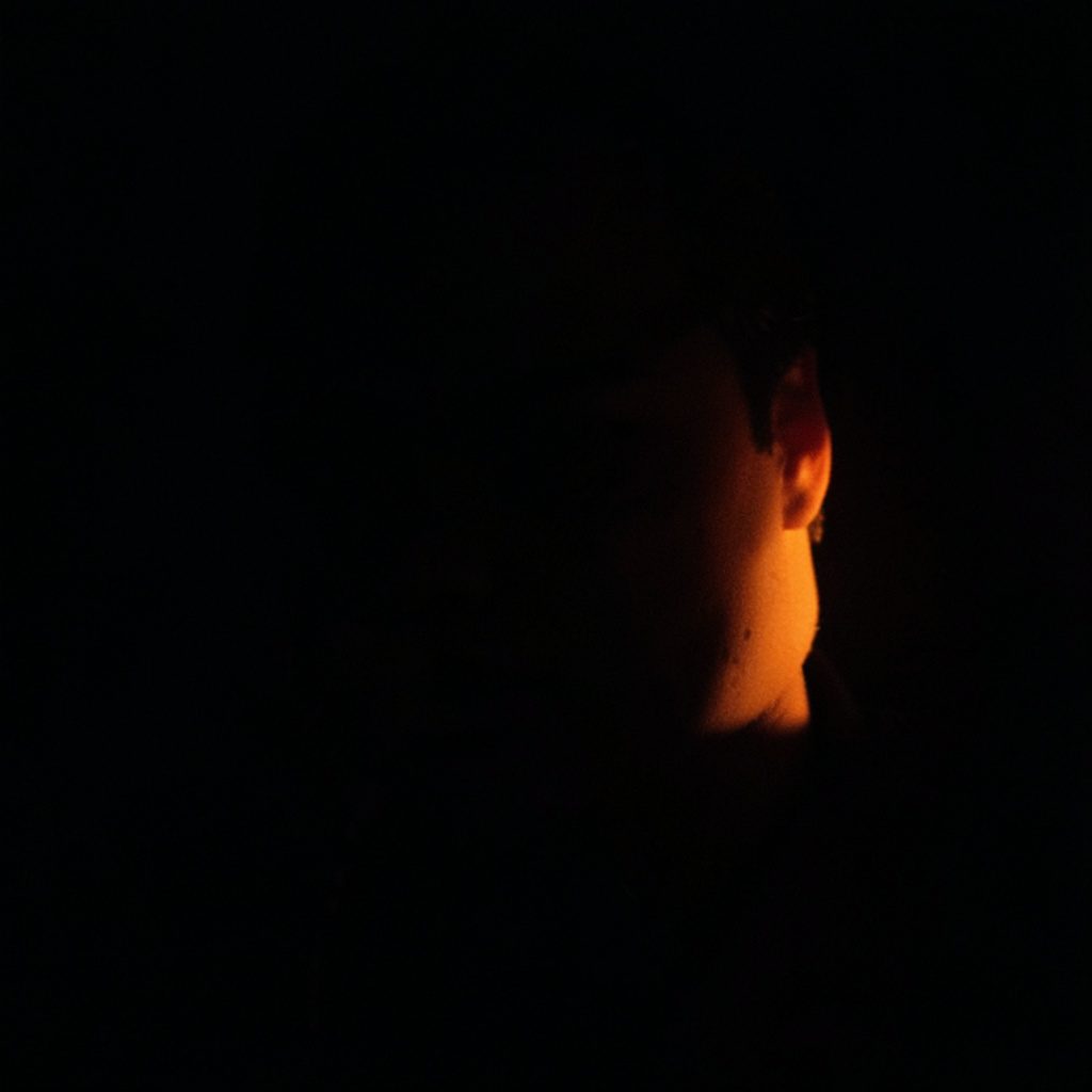 Dark abstract digital landscape with glowing orange and amber circuit-like patterns emerging from deep shadow, evoking technology and gaming energy.
